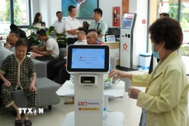 Người dân trải nghiệm các robot phục vụ. (Ảnh: Hữu Duyên/TTXVN)