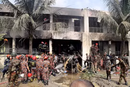 Hiện trường vụ rơi máy bay huấn luyện xuống khuôn viên trường học ở thủ đô Dhaka. (Ảnh: Reuters)