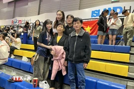 Châu Tuyết Vân (ngoài cùng bên trái) “cô gái vàng” của Teakwondo Việt Nam từng đoạt 8 Huy chương Vàng SEA Games, cùng bố mẹ tới sân cổ vũ cho đội tuyển Việt Nam. (Ảnh: Đỗ Sinh/TTXVN)