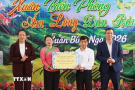 Lãnh đạo xã Khổng Lào trao quà Tết cho đại diện bản Nà Vàng. (Ảnh: Quý Trung/TTXVN)