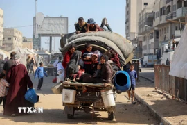 Người dân Palestine mang theo đồ đạc trở về thành phố Gaza ngày 11/10/2025. (Ảnh: THX/TTXVN)