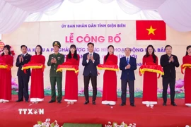 Các đại biểu thực hiện nghi thức cắt băng công bố Quyết định của UBND tỉnh Điện Biên về Cửa khẩu A Pa Chải. (Ảnh: TTXVN phát)