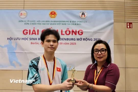 Tham tán Hà Thị Lâm Hồng trao giải nhất đơn nam cho vận động viên Nguyễn Sỹ Cảnh, Hội LHS Berlin - Brandenburg. (Ảnh: Phương Hoa/TTXVN)