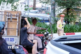 Lực lượng CSGT thuộc Tổ công tác đặc biệt Công an TP Hà Nội dừng xe, kiểm tra và xử lý 1 trường hợp người điều khiển xe ba bánh, bốn bánh tự sản xuất, lắp ráp chở hàng cồng kềnh. (Ảnh: Phạm Kiên/TTXVN)