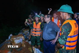 Thủ tướng Phạm Minh Chính chỉ đạo phòng chống lũ, ứng cứu sự cố, bảo đảm an toàn tuyến đê hữu Cầu. (Ảnh: Dương Giang/TTXVN)
