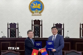 Chánh án Tòa án Nhân dân Tối cao Lê Minh Trí (trái) và Chánh án Tòa án Tối cao Mông Cổ Ganzorig Damdin trao đổi Bản ghi nhớ hợp tác giữa hai bên. (Ảnh: Công Tuyên/TTXVN)