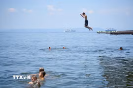 Người dân tắm biển tránh nóng tại Vladivostok, Nga. (Ảnh: THX/TTXVN)