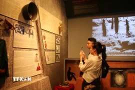 Du khách tham quan khu trưng bày chuyên đề “Ẩm thực Nam Bộ thời kháng chiến”. (Ảnh: Thu Hương/TTXVN)