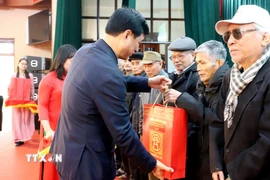 Ủy viên Bộ Chính trị, Bí thư Thành ủy Hà Nội Nguyễn Duy Ngọc trao quà Tết tặng các gia đình. (Ảnh: Thế Duyệt/TTXVN)