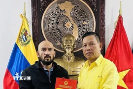 Đại sứ Việt Nam tại Venezuela tặng quà lưu niệm cho Giáo sư José Javier Díaz Macadan. (Ảnh: TTXVN phát)