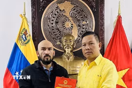 Đại sứ Việt Nam tại Venezuela tặng quà lưu niệm cho Giáo sư José Javier Díaz Macadan. (Ảnh: TTXVN phát)