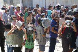 Trẻ em xếp hàng nhận thức ăn cứu trợ tại trại tị nạn Jabalia ở Dải Gaza. (Ảnh: THX/TTXVN)