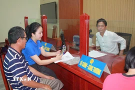 Thanh niên xã Tân Thuận (tỉnh Hưng Yên) hỗ trợ người dân thực hiện thủ tục hành chính tại Trung tâm phục vụ hành chính công xã Tân Thuận. (Ảnh: Thu Hoài/TTXVN)