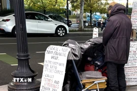 Một người vô gia cư với tấm biển cần giúp đỡ về tài chính trên một tuyến phố ở trung tâm thủ đô Washington D.C. (Ảnh: Ngọc Quang/TTXVN)