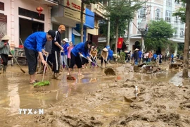 Các lực lượng thanh niên tình nguyện được huy động để giúp dân dọn dẹp nhà ở, vệ sinh đường phố. (Ảnh: TTXVN)