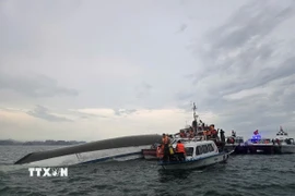 Lực lượng chức năng tiếp cận tàu đắm tiến hành cứu hộ, cứu nạn. (Ảnh: Thanh Vân/TTXVN)