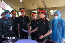 Đoàn công tác Quân khu 4 kiểm tra, thăm hỏi, động viên và tặng quà các lực lượng đang thực hiện nhiệm vụ lấy mẫu, số hóa thông tin và bàn giao mẫu hài cốt liệt sỹ tại Nghĩa trang Liệt sĩ Quốc gia Đường 9. (Ảnh: TTXVN phát)