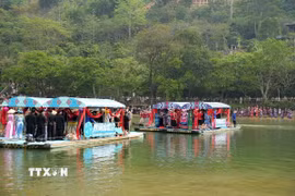 Văn nghệ sỹ hai bên tham gia hát đối trên sông. (Ảnh: Chu Hiệu/TTXVN)