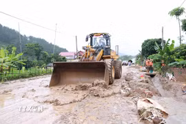 Các lực lượng nỗ lực khắc phục hậu quả mưa lũ tại xã Mường Than. (Ảnh: Quý Trung/TTXVN)