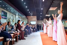 Phu nhân Ngô Phương Ly và các đại biểu hưởng ứng bài hát "Việt Nam - Trung Hoa", một sáng tác nổi tiếng của nhạc sĩ Đỗ Nhuận được tập thể giảng viên và sinh viên học viện trình bày. (Ảnh: TTXVN phát)