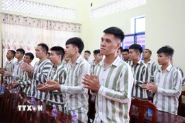 Các phạm nhân tại Trại giam A2 vỗ tay chúc mừng sau khi nghe công bố Quyết định đặc xá của Chủ tịch nước. (Ảnh: Tiên Minh/TTXVN)