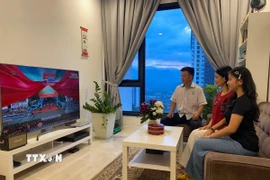 Gia đình anh Lê Văn Hùng xem truyền hình trực tiếp buổi lễ kỷ niệm 50 năm Ngày Giải phóng miền Nam, thống nhất đất nước. (Ảnh: Hằng Linh/TTXVN)