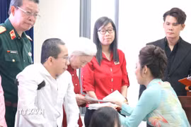Đại diện Ban tổ chức tặng quà nạn nhân chất độc da cam/dioxin Thành phố Hồ Chí Minh. (Ảnh: Thanh Vũ/TTXVN)