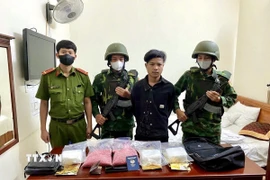 Đối tượng TonSakSith LatXaKham cùng tang vật vụ án. (Ảnh: TTXVN phát)