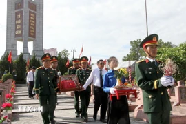 Nghi lễ an táng 76 hài cốt liệt sỹ quân tình nguyện và chuyên gia Việt Nam hi sinh tại Lào. (Ảnh: Văn Tý/TTXVN