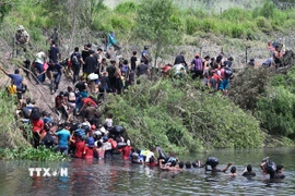 Người di cư vượt sông Rio Grande để vào Mỹ từ thành phố Matamoros, bang Tamaulipas, Mexico, ngày 11/5/2023. (Ảnh: AFP/TTXVN)