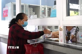 Bệnh nhân khám Bảo hiểm y tế nhận thuốc tại bệnh viện. (Ảnh: Minh Phú/TTXVN)