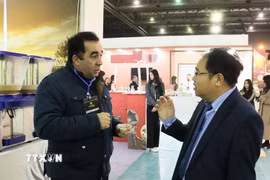 Ông Hoàng Đức Nhuận, Tham tán Thương mại Việt Nam tại Algeria trao đổi với đại diện một doanh nghiệp Algeria xuất khẩu bột minh quyết sang Việt Nam. (Ảnh: Mạnh Hùng/TTXVN)