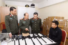 Đối tượng Vi Văn Duy (ngồi) cùng tang vật bị thu giữ. (Ảnh: TTXVN phát)