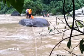 Chiến sỹ Đồn Biên phòng Pa Vệ Sử, Lai Châu, kịp thời cứu 3 người dân bị mắc kẹt giữa dòng nước lũ tại khu vực hồ thủy điện Nậm Sì Lường, xã Bum Nưa, tỉnh Lai Châu. (Ảnh: TTXVN phát)