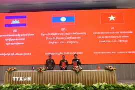 Bộ trưởng Quốc phòng Việt Nam-Lào-Campuchia ký biên bản cuộc gặp. (Ảnh: Xuân Tú/TTXVN)