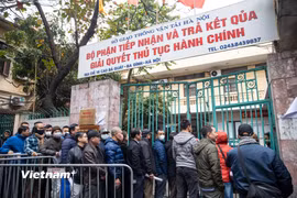 Người dân Hà Nội xếp hàng chờ vào làm thủ tục cấp đổi giấy phép lái xe. (Ảnh: Minh Sơn/Vietnam+)