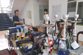 Cơ quan Công an thu giữ nhiều bình khí N2O, dụng cụ pha chế, sử dụng shisha và rượu ngoại. (Ảnh: TTXVN phát)