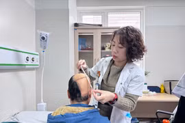 Bác sỹ theo dõi tình trạng của bệnh nhân sau phẫu thuật. (Ảnh: PV/Vietnam+)