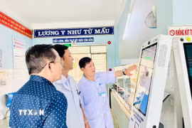 Cán bộ y tế hướng dẫn vận hành ki-ốt thông minh tại cơ sở y tế. (Ảnh: Quang Thái/TTXVN)