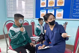 Các bác sỹ khám mắt cho học sinh Trường Tiểu học Đào Xá. (Ảnh: PV/Vietnam+)