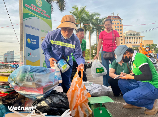 Người dân hào hứng tham gia chương trình thu đổi rác tái chế lấy các vật dụng cần thiết tại buổi lễ phát động. (Ảnh: Thanh Phong/Vietnam+) vnp-moitruong03.jpg