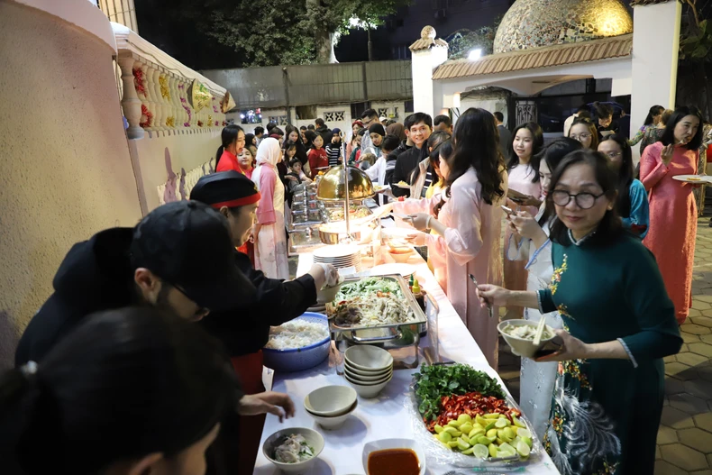 Bà con cộng đồng người Việt tại Ai Cập và bạn bè quốc tế thưởng thức các món ăn truyền thống của Việt Nam. (Ảnh: Nguyễn Trường/TTXVN)