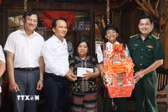 Phó Bí thư Thường trực Thành ủy Đà Nẵng Nguyễn Đình Vĩnh tặng quà cho gia đình ông Clau BhLao ở thôn Vòng, xã Hùng Sơn. (Ảnh: Đoàn Hữu Trung/TTXVN)