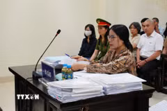 Bị cáo Nguyễn Thị Bình (đeo kính) và bị cáo Phạm Thị Minh Nguyệt (mặc áo sẫm màu, đeo khẩu trang trắng) tại phiên xử. (Ảnh: Kim Anh/TTXVN)