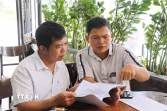 Tòa Phúc thẩm Tòa án nhân dân tối cao tại Đà Nẵng tuyên ông Nguyễn Trần Tấn Hiệp (bên phải) thắng kiện nhưng hơn 4 tháng qua Ủy ban nhân dân xã Đình Cương chưa thi hành bản án. (Ảnh: Phạm Cường/TTXVN)