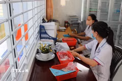 Nhân viên y tế Trạm Y tế tại Đồng Tháp xử lý thông tin bệnh nhân đến khám bệnh trên hệ thống bảo hiểm y tế liên thông. (Ảnh: Hữu Chí/TTXVN)