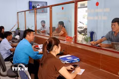 Cán bộ Trung tâm Phục vụ hành chính công xã Lao Chải (Tuyên Quang) hướng dẫn, giải quyết thủ tục hành chính cho người dân. (Ảnh: Đức Thọ/TTXVN)