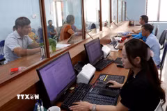 Cán bộ Trung tâm Phục vụ hành chính công xã Lao Chải hướng dẫn, giải quyết thủ tục hành chính cho người dân theo hướng công khai, hiện đại và hiệu quả. (Ảnh: Đức Thọ/TTXVN)
