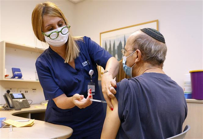 Nhân viên y tế tiêm vaccine ngừa COVID-19 cho người dân tại Tel Aviv (Israel), ngày 12/7/2021. (Ảnh: AFP/TTXVN) COVID-19: Chủ động ngăn chặn để hạn chế thiệt hại về người ảnh 2