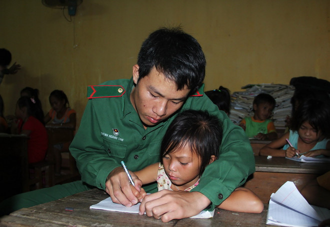 Dù là lớp học phổ cập xóa mù chữ, nhưng các em nhỏ luôn được những thầy giáo mang quân hàm xanh ở Đồn biên phòng Tuyên Bình chỉ bảo tận tình. (Ảnh: Trường Giang/TTXVN) Tận tụy mang “con chữ” đến với trẻ em Việt kiều Campuchia ảnh 1